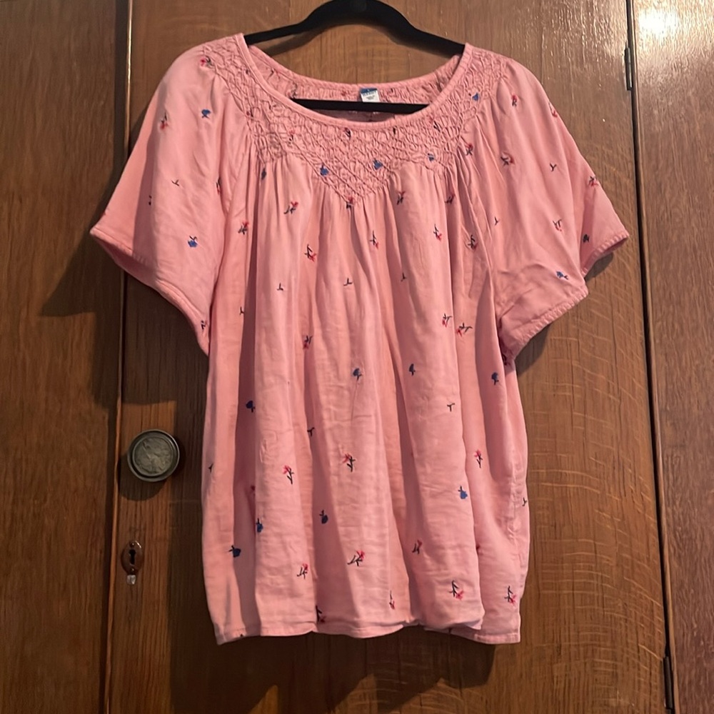 Babydoll style pink embroidered flowered blouse.